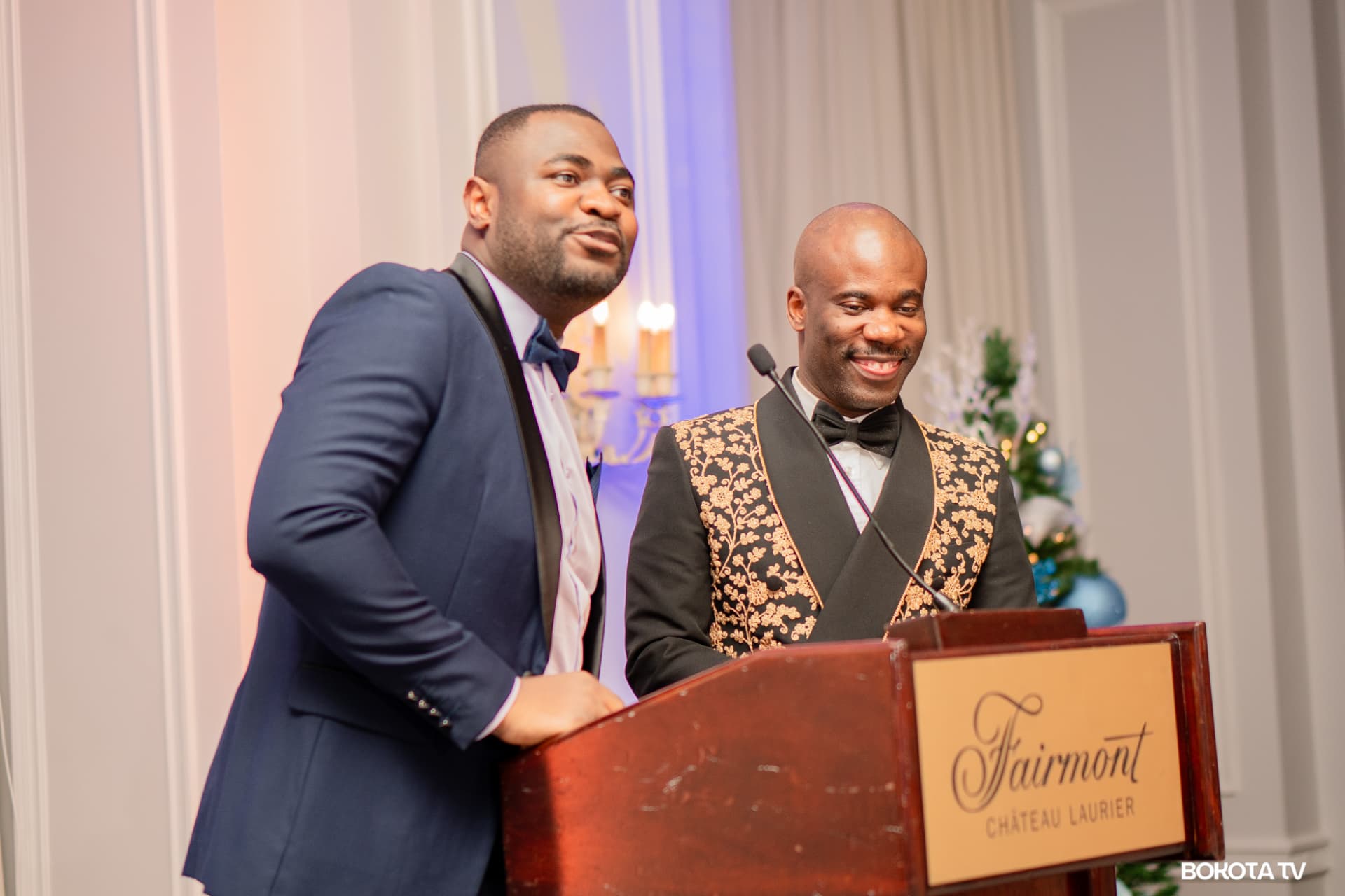 Two hosts share a light moment at the Fairmont Château Laurier podium