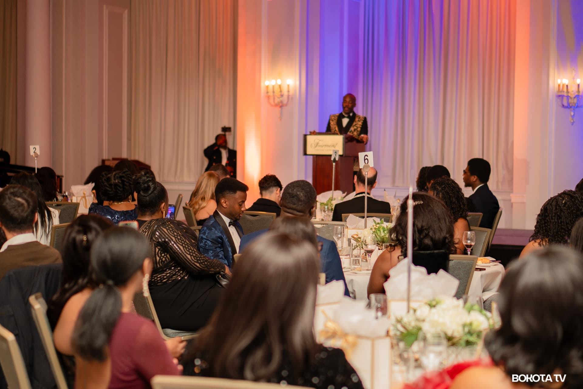 Guests seated at dinner tables look on as a speaker addresses the room from the Fairmont Château Laurier podium
