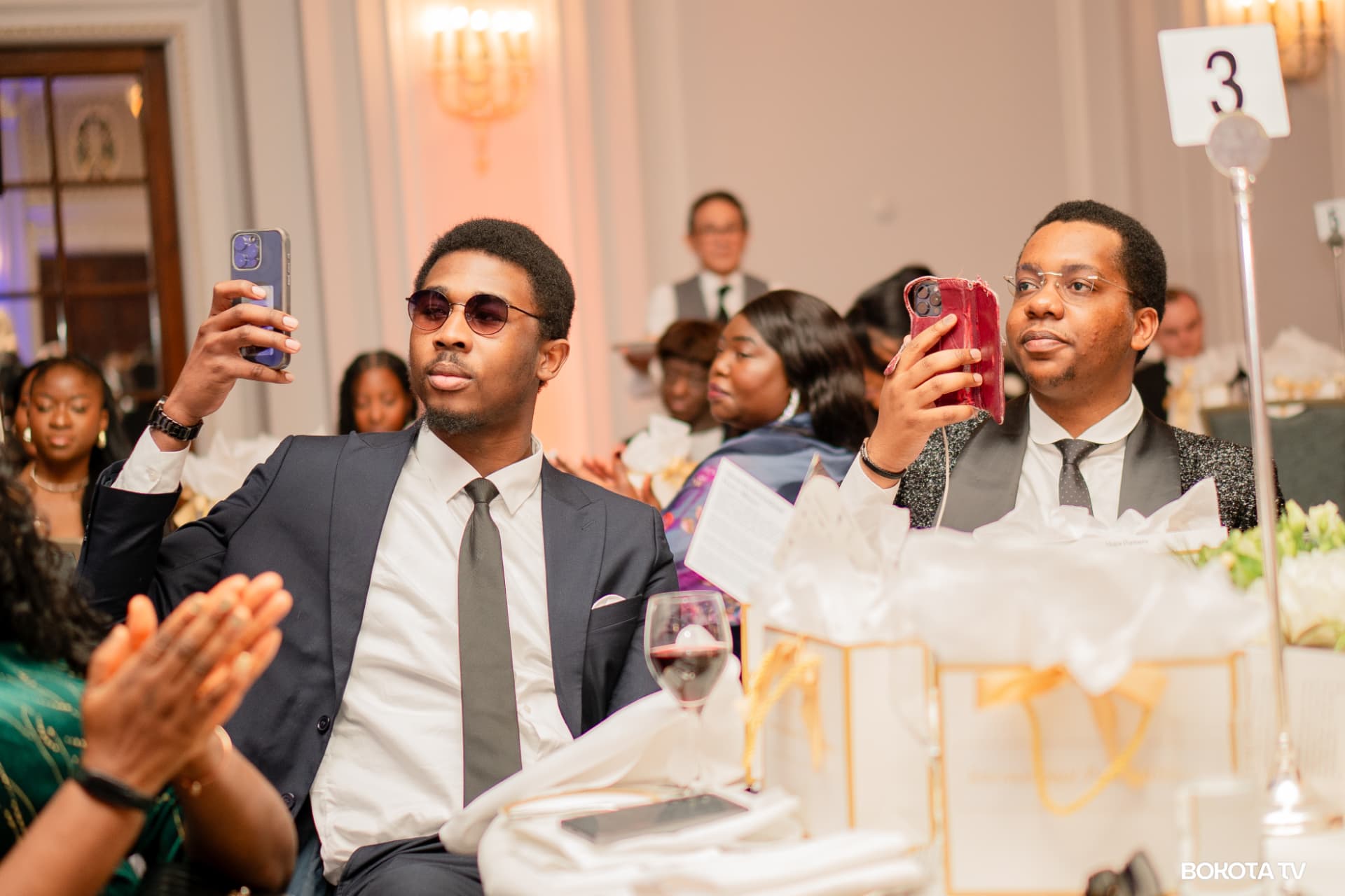 Guests capture the evening on their phones as the room applauds