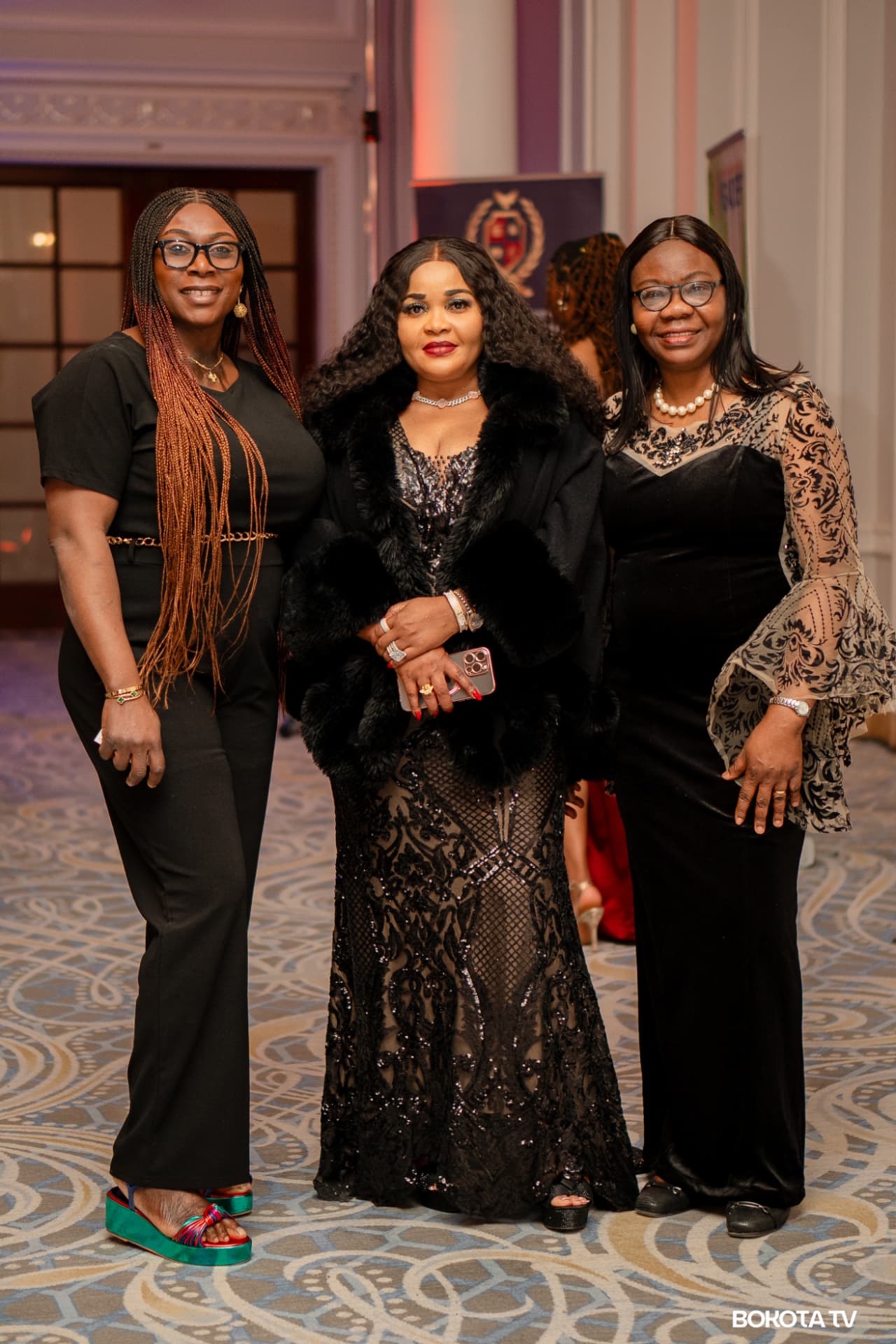 Three guests in evening wear pose in the ballroom foyer