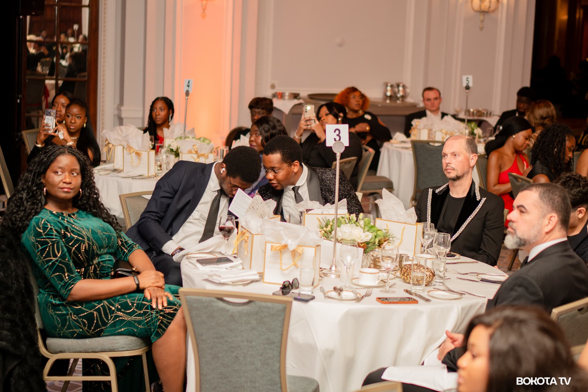 Guests at a dinner table review the evening programme during MBOMBO Gala Night